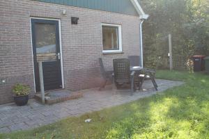 a patio with a table and chairs next to a house at duin/vuurtorenzicht in De Cocksdorp