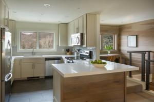 a kitchen with a white island in a kitchen with a refrigerator at Ridge 91 at Elkhorn in Elkhorn Village