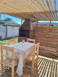 a table and chairs under a wooden roof with a grill at Tamara in La Paloma