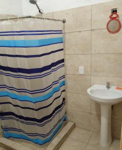 a bathroom with a shower curtain and a sink at Tamara in La Paloma