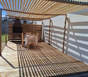 a wooden deck with a table and an outdoor oven at Tamara in La Paloma