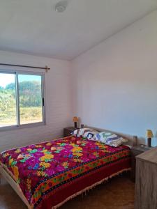 a bedroom with a bed with a colorful blanket at Tamara in La Paloma