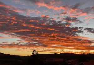 ein Sonnenuntergang mit Wolken am Himmel in der Unterkunft Carmelo Morada do Sol in Tomazina