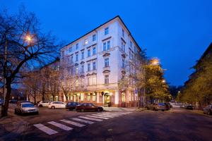 a large white building on a city street at night at Aron in Prague