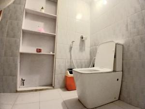 a small bathroom with a toilet and a shower at Rose Apple Hostel in Ahangama