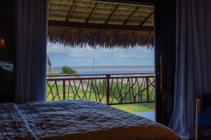 a bedroom with a bed and a view of the ocean at Áurea chalés in Tutóia