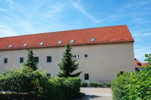 a large building with a red roof with windows at Apartments in Leuna in Leuna