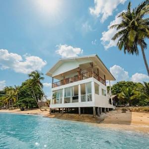 a villa on the beach with a palm tree at Beach Studio Level - WaveSide Ocean Bliss in Ko Phangan