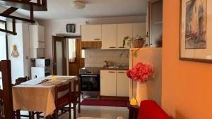 a small kitchen with a table and a refrigerator at casa di Gio in Sondrio