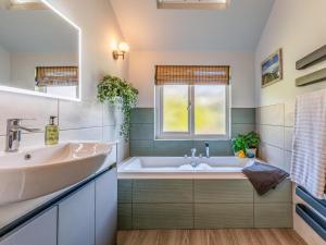 a bathroom with a tub and a sink and a window at 5 Bed in Fowey oc-93849 in Polruan +33 photos