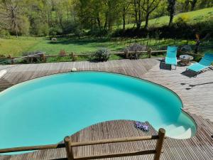 a swimming pool with two chairs and a table at Roulotte Manoé in Liéoux