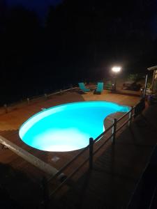 a swimming pool at night with two lounge chairs at Roulotte Manoé in Liéoux