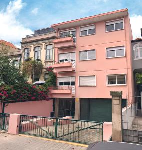 a pink building with a gate in front of it at Coliving moderno com lindo jardim in Porto