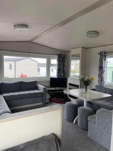 a living room with couches and a table at Shellie's Summer Breeze Retreat in Heysham