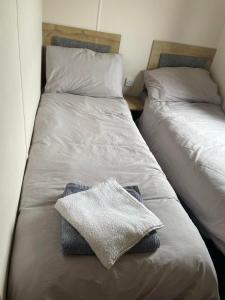 two beds sitting next to each other in a bedroom at Shellie's Summer Breeze Retreat in Heysham +28 photos