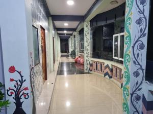 a hallway of a building with paintings on the walls at Abi Hotel & Rastaurant in Jaffna