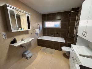 a bathroom with a sink and a tub and a toilet at Maxi Apartman in Budaörs