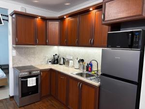 a kitchen with wooden cabinets and a stainless steel refrigerator at Maxi Apartman in Budaörs +12 photos