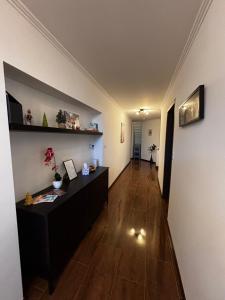 a living room with a table and a hallway at Maxi Apartman in Budaörs