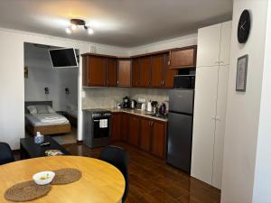 a kitchen with wooden cabinets and a table in a room at Maxi Apartman in Budaörs