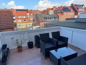 a balcony with two chairs and a table at Vina Ferienwohnung in Emden