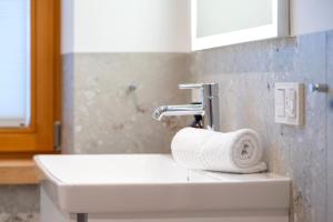 a sink in a bathroom with a towel on it at Ferienwohnung Dorfmitte in Reit im Winkl +19 photos