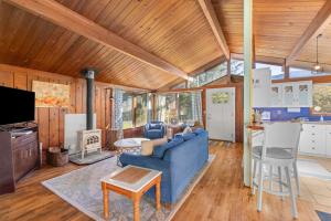 a living room with a blue couch and a kitchen at The Lily Pad in Rockaway Beach