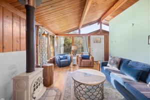 a living room with a blue couch and a wood stove at The Lily Pad in Rockaway Beach