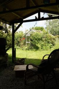 a porch with chairs and a table in a yard at Slapen bij de molenaar in Leerdam +21 photos