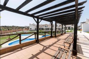 a patio with benches and a swimming pool at El rincón de Bonilla in El Ronquillo