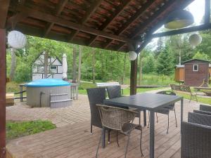a patio with a table and chairs and a grill at small house "Urgas" by the sea with 6 beds in Plieņciems