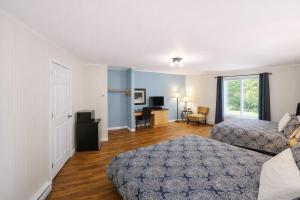 a bedroom with two beds and a desk in it at Motel Au Vieux Frontenac in Thetford Mines