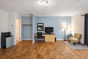 an empty room with a desk with a computer and chairs at Motel Au Vieux Frontenac in Thetford Mines +26 photos