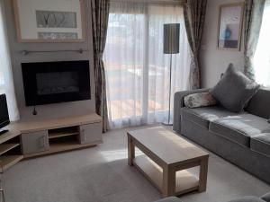a living room with a couch and a tv at Yew in Denny