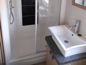 a bathroom with a white sink and a shower at Yew in Denny +10 photos