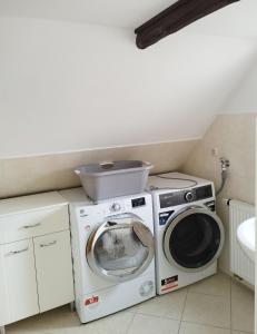 a laundry room with a washer and a washing machine at "Ferienhaus-Ottendorf" mit Pool und Infarotkabine in Ottendorf