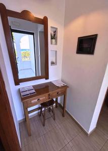 a bathroom with a wooden desk and a mirror at Evi Apartments And Studios in Theologos