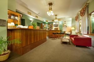 a waiting room with a red couch and a bar at Aron in Prague