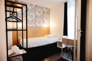 a room with a bed and a desk and a bunk bed at Brit Hotel L'Arrivée Guingamp in Guingamp +40 photos