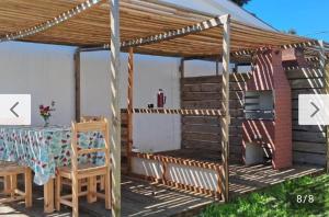a pergola on a deck with a table and chairs at Rodolfo in La Paloma