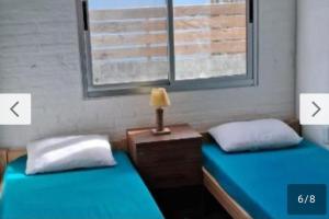 a room with two beds and a lamp on a night stand at Rodolfo in La Paloma