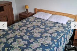 a bedroom with a bed with a blue floral bedspread at Rodolfo in La Paloma