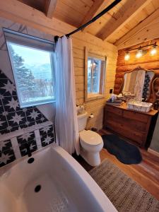 a bathroom with a toilet and a bath tub at Little Bear Getaway Cabins in Glacier View +90 photos