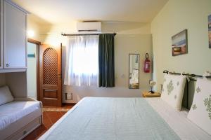 a bedroom with a large bed and a window at Cala Del Faro House in Arzachena