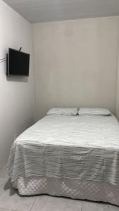 a bedroom with a bed with a tv on the wall at Lar Aconchego climatizado e compartilhado in Aracaju