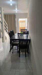 a dining room with a black table and chairs at Lar Aconchego climatizado e compartilhado in Aracaju
