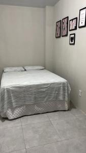 a bed in a bedroom with pictures on the wall at Lar Aconchego climatizado e compartilhado in Aracaju +12 photos