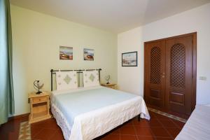 a bedroom with a bed and a wooden door at Cala Del Faro House in Arzachena