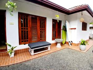 a house with a bench and two surfboards in it at Rose Apple Hostel in Ahangama +3 photos