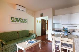 a living room with a green couch and a table at Cala Del Faro House in Arzachena +12 photos